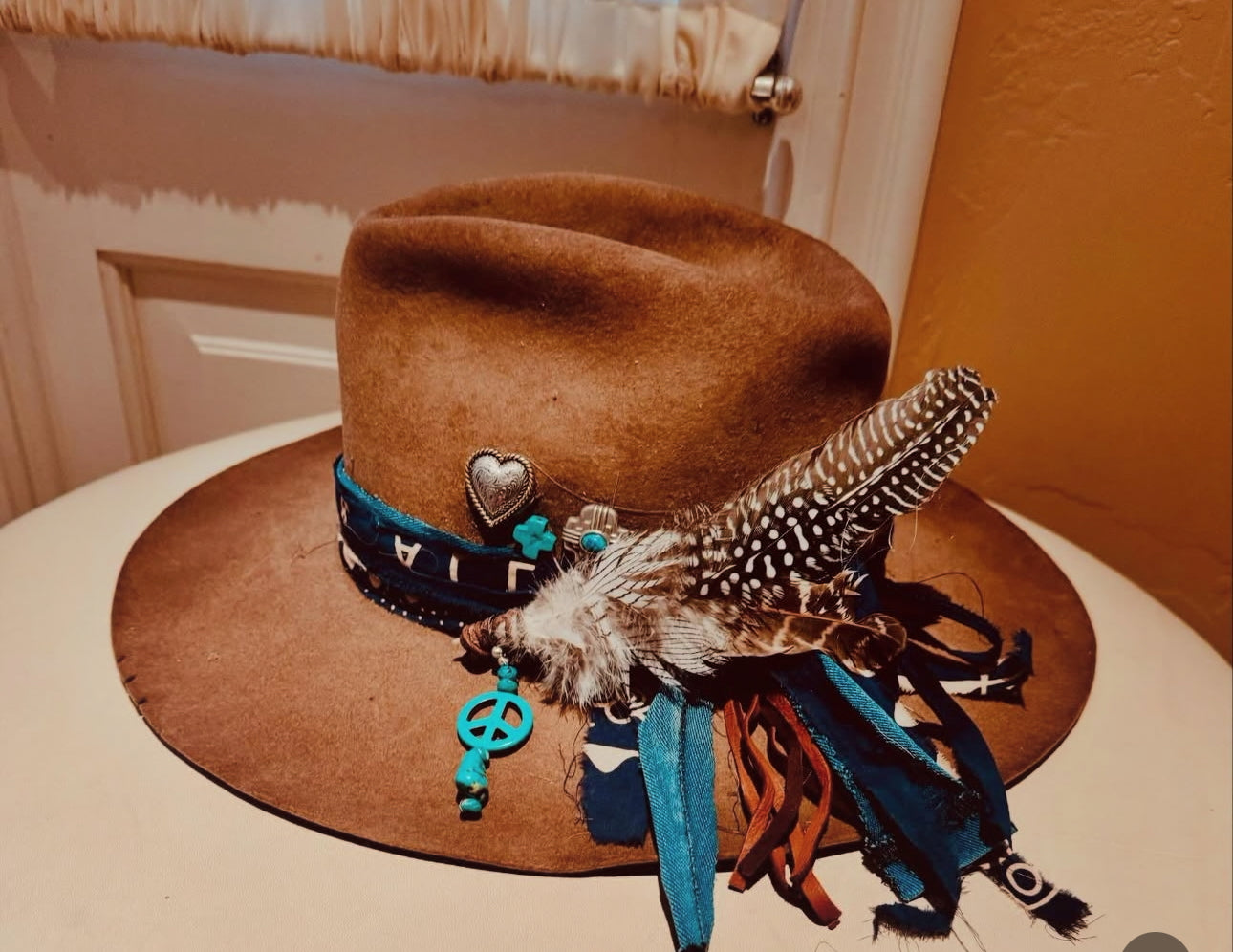 Brown cowboy hat with decorative elements on a white surface